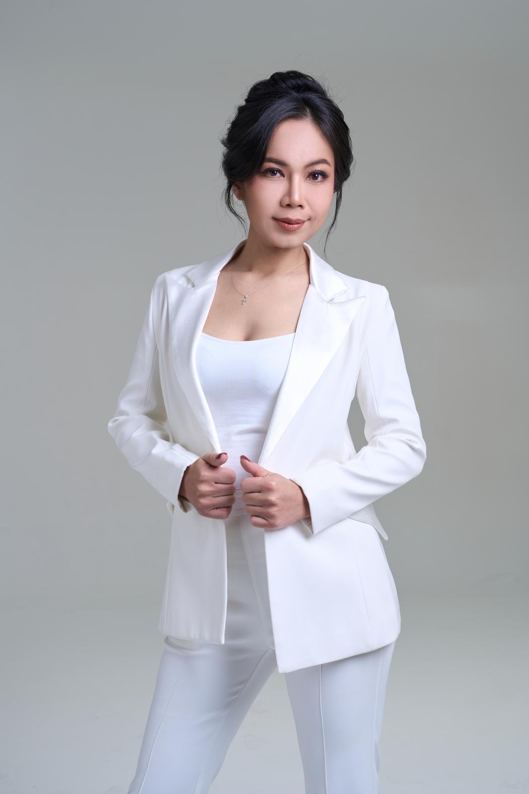 Kate Ketsuda, the Queen of Gold Trading, in a white suit